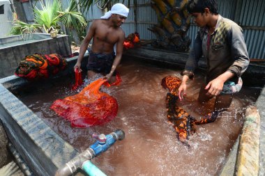 Bangladeşli işçiler 26 Nisan 2018 'de Bangladeş' in Dhaka yakınlarındaki Narsingdi bölgesinde Batik Kumaş endüstrisinde çalışmaktadır. Her işçi 400-500 Taka ya da 5-6 Amerikan Doları kazanır..