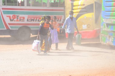 12 Kasım 2020 'de Bangladeş' in Dhaka kentindeki tozlu bir yolda insanlar yürür. Dhaka şehrinin kliması, şehrin pek çok kesimindeki yeni yol inşaatları nedeniyle son iki yıldır endişe verici bir hızla günden güne kötüleşiyor..