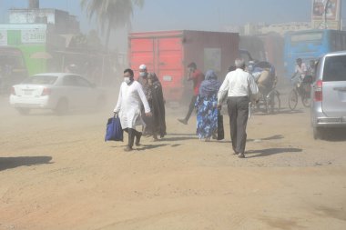 12 Kasım 2020 'de Bangladeş' in Dhaka kentindeki tozlu bir yolda insanlar yürür. Dhaka şehrinin kliması, şehrin pek çok kesimindeki yeni yol inşaatları nedeniyle son iki yıldır endişe verici bir hızla günden güne kötüleşiyor..