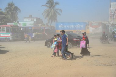 12 Kasım 2020 'de Bangladeş' in Dhaka kentindeki tozlu bir yolda insanlar yürür. Dhaka şehrinin kliması, şehrin pek çok kesimindeki yeni yol inşaatları nedeniyle son iki yıldır endişe verici bir hızla günden güne kötüleşiyor..