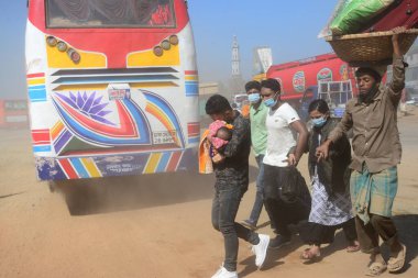 12 Kasım 2020 'de Bangladeş' in Dhaka kentindeki tozlu bir yolda insanlar yürür. Dhaka şehrinin kliması, şehrin pek çok kesimindeki yeni yol inşaatları nedeniyle son iki yıldır endişe verici bir hızla günden güne kötüleşiyor..