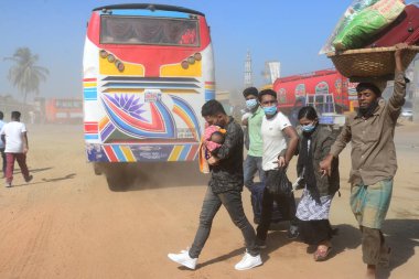 12 Kasım 2020 'de Bangladeş' in Dhaka kentindeki tozlu bir yolda insanlar yürür. Dhaka şehrinin kliması, şehrin pek çok kesimindeki yeni yol inşaatları nedeniyle son iki yıldır endişe verici bir hızla günden güne kötüleşiyor..
