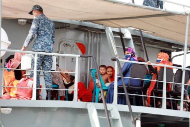 Rohingya mültecileri Bangladeş 'in Chittagong, Bangladeş' teki Bhashan Char adasına nakledilmek üzere 4 Aralık 2020 'de bir Bangladeş donanma gemisine biniyorlar. - Bangladeş, yüzlerce Rohingya mültecisini Perşembe günü düşük seviyeli bir adaya transfer etmeye başladı..