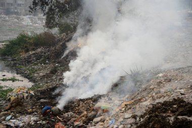 6 Aralık 2020 'de Bangladeş' in Dhaka kentindeki Buriganga Nehri 'nin kıyısında çöp yakarak oynayan çocuklar zehirli dumanlar yarattılar. Dhaka dünyanın en kirli şehirlerinden biri olarak sıralamaya devam ediyor..