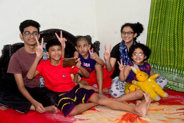 2 Ocak 2021 'de Dhaka, Bangladeş' teki COVID-19 Coronavirus salgını sırasında evlerinde oyun oynamak için cep telefonu kullanan çocuklar