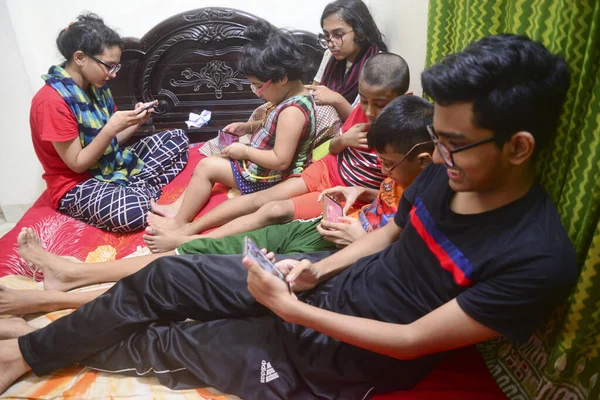 2 Ocak 2021 'de Dhaka, Bangladeş' teki COVID-19 Coronavirus salgını sırasında evlerinde oyun oynamak için cep telefonu kullanan çocuklar