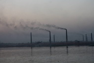 Buriganga Nehri kıyısındaki tuğla fabrikaları. Bu fabrikaların bacalarından çıkan kara duman çevreye ve ekosisteme ciddi bir tehdit oluşturuyor. Dhaka, Bangladeş.