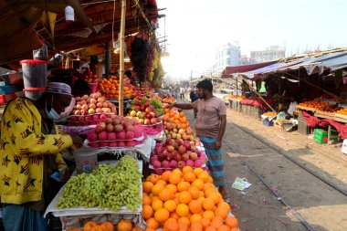 Bangladeşli bir satıcı 31 Ocak 2021 'de Dhaka, Bangladeş' te demiryolu boyunca meyve satıyor..