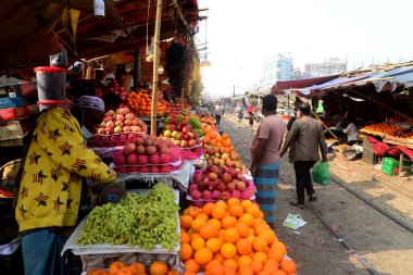 Bangladeşli bir satıcı 31 Ocak 2021 'de Dhaka, Bangladeş' te demiryolu boyunca meyve satıyor..