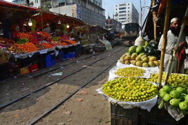 Bangladeşli bir satıcı 31 Ocak 2021 'de Dhaka, Bangladeş' te demiryolu boyunca meyve satıyor..