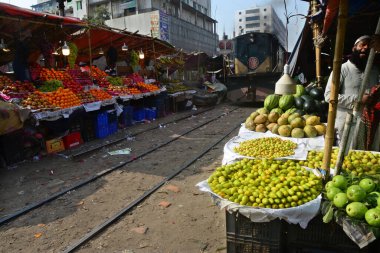 Bangladeşli bir satıcı 31 Ocak 2021 'de Dhaka, Bangladeş' te demiryolu boyunca meyve satıyor..