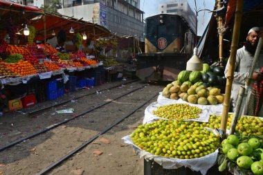 Bangladeşli bir satıcı 31 Ocak 2021 'de Dhaka, Bangladeş' te demiryolu boyunca meyve satıyor..