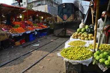 Bangladeşli bir satıcı 31 Ocak 2021 'de Dhaka, Bangladeş' te demiryolu boyunca meyve satıyor..