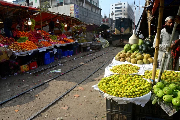 Bangladeşli bir satıcı 31 Ocak 2021 'de Dhaka, Bangladeş' te demiryolu boyunca meyve satıyor..