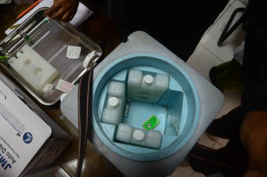 7 Şubat 2021 'de Dhaka, Bangladeş' te, ülkenin dört bir yanında aşı yapılmaya başlanırken Sheikh Russell Ulusal Gastro Karaciğer Enstitüsü 'nde bir doz Covid-19 aşısı bir buz torbasıyla görüldü.. 