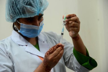 10 Şubat 2021 'de Dhaka, Bangladeş' teki Dhaka Tıp Kolajı ve Hastanesi 'nde COVID-19 aşısı hazırlayan bir tıbbi personel