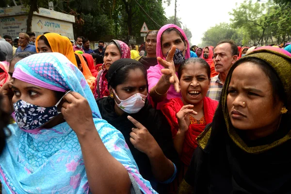 Dikiş Kuyusu Limited and Apparel Stitch Limited şirketinin giyim işçileri 16 Mart 2021 'de Dhaka, Bangladeş' te hak ettikleri ücreti talep eden bir yol bloğu gösterisini sahneledi.