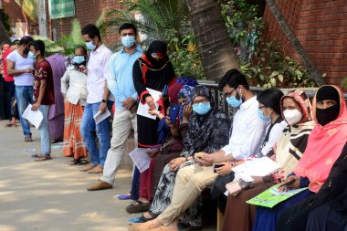 Bölge sakinleri, 23 Mart 2021 'de Bangladeş' in Dhaka kentindeki Shaheed Suhrawardy Tıp Fakültesi & Hastanesi 'nde COVID-19 Coronavirus testi için örnek toplama kabininin önünde bekliyorlar.