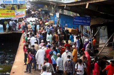 İnsanlar, 5 Nisan 2021 'de hükümet Covid-19 Coronavirus' a karşı önleyici tedbir olarak tecrit uygulayacağı için, Bangladeş 'in Dhaka kentindeki evlerine dönmek için sosyal mesafelerini korumadan feribota tıkıştırıyorlar.