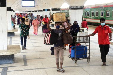 Bangladeş, Dhaka 'daki Coronavirus salgını sırasında 25 Mayıs 2020' de tren istasyonuna yüz maskesi takan yolcular geliyor..