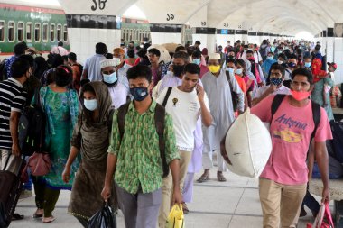Bangladeş, Dhaka 'daki Coronavirus salgını sırasında 25 Mayıs 2020' de tren istasyonuna yüz maskesi takan yolcular geliyor..