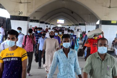 Bangladeş, Dhaka 'daki Coronavirus salgını sırasında 25 Mayıs 2020' de tren istasyonuna yüz maskesi takan yolcular geliyor..
