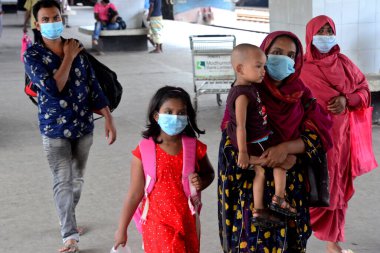 Bangladeş, Dhaka 'daki Coronavirus salgını sırasında 25 Mayıs 2020' de tren istasyonuna yüz maskesi takan yolcular geliyor..