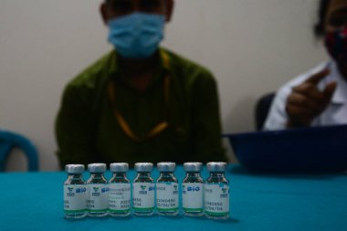 Sağlık çalışanı 29 Mayıs 202 'de Dhaka, Bangladeş' teki Dhaka Tıp Fakültesi 'nde bir doz Çin Sinopharm COVID-19 aşısı gösteriyor.