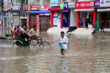Vatandaşlar ve araçlar 1 Haziran 2021 'de sağanak yağış neredeyse durgunluğa yol açtıktan sonra Dhaka' nın sulak caddelerinde ilerlemeye çalışırlar. Muson yağmurlarının ardından Bangladeş 'in başkenti Dhaka' daki bölgenin çoğu sular altında kaldı..