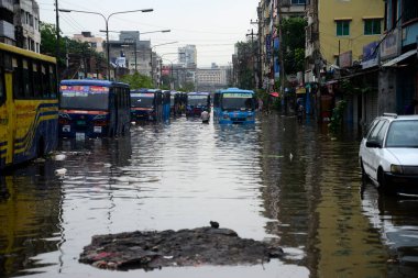 Vatandaşlar ve araçlar 1 Haziran 2021 'de sağanak yağış neredeyse durgunluğa yol açtıktan sonra Dhaka' nın sulak caddelerinde ilerlemeye çalışırlar. Muson yağmurlarının ardından Bangladeş 'in başkenti Dhaka' daki bölgenin çoğu sular altında kaldı..