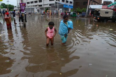 Vatandaşlar, 1 Haziran 2021 'de sağanak yağış neredeyse durgunluğa yol açtıktan sonra, Dhaka' nın sulak sokaklarında dolaşmaya çalışıyorlar. Muson yağmurlarının ardından Bangladeş 'in başkenti Dhaka' daki bölgenin çoğu sular altında kaldı..