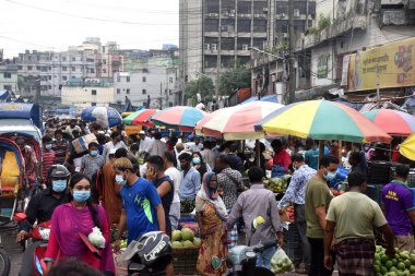 Bangladeş yetkilileri 30 Haziran 2021 'de Bangladeş' in Dhaka kentindeki Covid-19 koronavirüsünün yayılmasını önleyecek yeni bir tecrit emri verdikten sonra halk sebze pazarında toplandı..