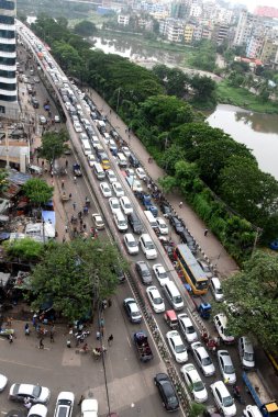 Bangladeş yetkililerinin 30 Haziran 2021 'de Bangladeş' in Dhaka kentindeki Covid-19 coronavirüsünün yayılmasını engellemek için yeni bir tecrit emri vermeleri üzerine, banliyö sakinleri bir trafik sıkışıklığı içinde yollarına devam ediyorlar..