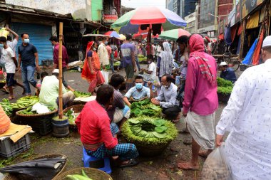 2 Temmuz 2021 'de Bangladeş' in Dhaka kentindeki Covid-19 Coronavirus kilitlenmesi sırasında insanlar sebze pazarında toplandı. Bangladeşli yetkililer, koronavirüs enfeksiyonları ve korondaki artışlar nedeniyle bir hafta boyunca ülke çapında tecrit ilan etti.