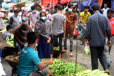 2 Temmuz 2021 'de Bangladeş' in Dhaka kentindeki Covid-19 Coronavirus kilitlenmesi sırasında insanlar sebze pazarında toplandı. Bangladeşli yetkililer, koronavirüs enfeksiyonları ve korondaki artışlar nedeniyle bir hafta boyunca ülke çapında tecrit ilan etti.