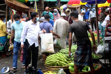 2 Temmuz 2021 'de Bangladeş' in Dhaka kentindeki Covid-19 Coronavirus kilitlenmesi sırasında insanlar sebze pazarında toplandı. Bangladeşli yetkililer, koronavirüs enfeksiyonları ve korondaki artışlar nedeniyle bir hafta boyunca ülke çapında tecrit ilan etti.
