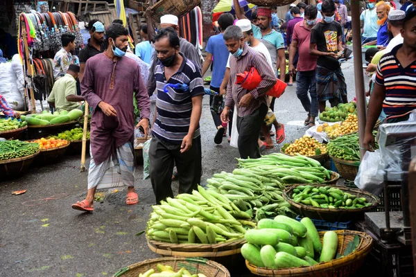 2 Temmuz 2021 'de Bangladeş' in Dhaka kentindeki Covid-19 Coronavirus kilitlenmesi sırasında insanlar sebze pazarında toplandı. Bangladeşli yetkililer, koronavirüs enfeksiyonları ve korondaki artışlar nedeniyle bir hafta boyunca ülke çapında tecrit ilan etti.