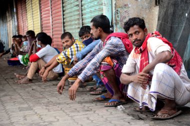 4 Temmuz 2021 'de Dhaka' daki Gabtali otobüs terminalinde Covid-19 koronavirüsünün yayılmasını kontrol altına almak için uygulanan tecrit sırasında evsiz insanlar yiyecek yardımı bekliyor.