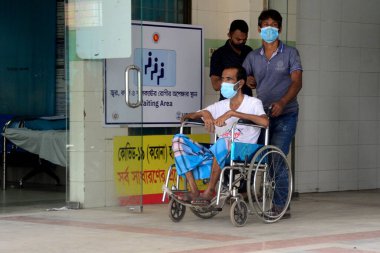 Akrabası, Bangladeş, Dhaka 'da 3 Temmuz 2021' de Coronavirus salgını sırasında tedavi görmek üzere Dhaka Tıp Fakültesi Hastanesi 'ne yatırılan Covid-19 adlı bir hastayı naklediyor..