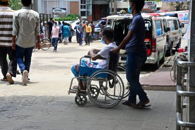 Akrabası, Bangladeş, Dhaka 'da 3 Temmuz 2021' de Coronavirus salgını sırasında tedavi görmek üzere Dhaka Tıp Fakültesi Hastanesi 'ne yatırılan Covid-19 adlı bir hastayı naklediyor..