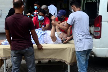 Akrabası, Bangladeş, Dhaka 'da 3 Temmuz 2021' de Coronavirus salgını sırasında tedavi görmek üzere Dhaka Tıp Fakültesi Hastanesi 'ne yatırılan Covid-19 adlı bir hastayı naklediyor..