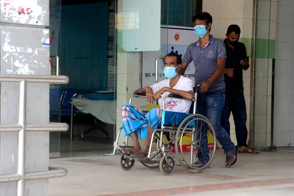 Akrabası, Bangladeş, Dhaka 'da 3 Temmuz 2021' de Coronavirus salgını sırasında tedavi görmek üzere Dhaka Tıp Fakültesi Hastanesi 'ne yatırılan Covid-19 adlı bir hastayı naklediyor..