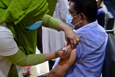 Bir sağlık çalışanı 24 Temmuz 202 'de Bangladeş, Dhaka' daki hastanede Covid-19 koronavirüsüne karşı bir doz Moderna aşısı olan bir adamı aşıladı.