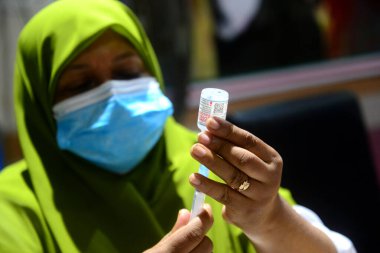 Bir sağlık çalışanı 24 Temmuz 202 'de Bangladeş, Dhaka' daki hastanede Covid-19 koronavirüsüne karşı bir doz Moderna aşısı olan insanları aşılamaya hazırlanıyor.