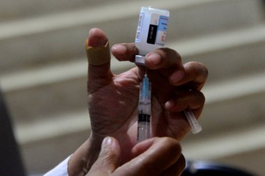 Bir sağlık çalışanı 22 Ağustos 2021 'de Bangladeş, Dhaka' daki Shamoli Aşı Merkezi 'nde yapılan toplu aşı sırasında ikinci bir doz Moderna COVID19 aşısını aşılamaya hazırlanıyor.