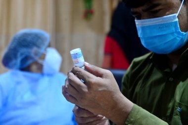 Bir sağlık çalışanı 22 Ağustos 2021 'de Bangladeş, Dhaka' daki Shamoli Aşı Merkezi 'nde yapılan toplu aşı sırasında ikinci bir doz Moderna COVID19 aşısını aşılamaya hazırlanıyor.