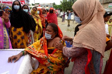 Bangladeş, Dhaka 'daki Korail Slum' daki geçici aşı merkezinde 28 Eylül 2021 'de bir doz Sinopharm COVID-19 aşısı olmayı bekliyorlar. Bangladeş Hükümeti 'nin ülke çapındaki toplu aşı programı 7,5 milyon enjekte etmeyi hedefliyor.