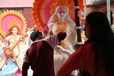 Bangladeşli kil sanatçısı 21 Ocak 2026 'da Bangladeş' in Dhaka kentindeki bir tapınakta Hindu Tanrıçası Saraswati 'nin heykeline boya uygular.