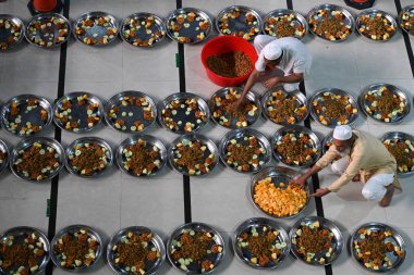 Gönüllüler, 22 Şubat 2026 'da Bangladeş' in Dhaka kentindeki Baitul Mukarram Ulusal Camii 'nde Ramazan ayındaki orucunu kırmadan önce Müslüman dindarlar için iftar yemeği hazırlıyorlar.