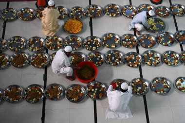 Gönüllüler, 22 Şubat 2026 'da Bangladeş' in Dhaka kentindeki Baitul Mukarram Ulusal Camii 'nde Ramazan ayındaki orucunu kırmadan önce Müslüman dindarlar için iftar yemeği hazırlıyorlar.